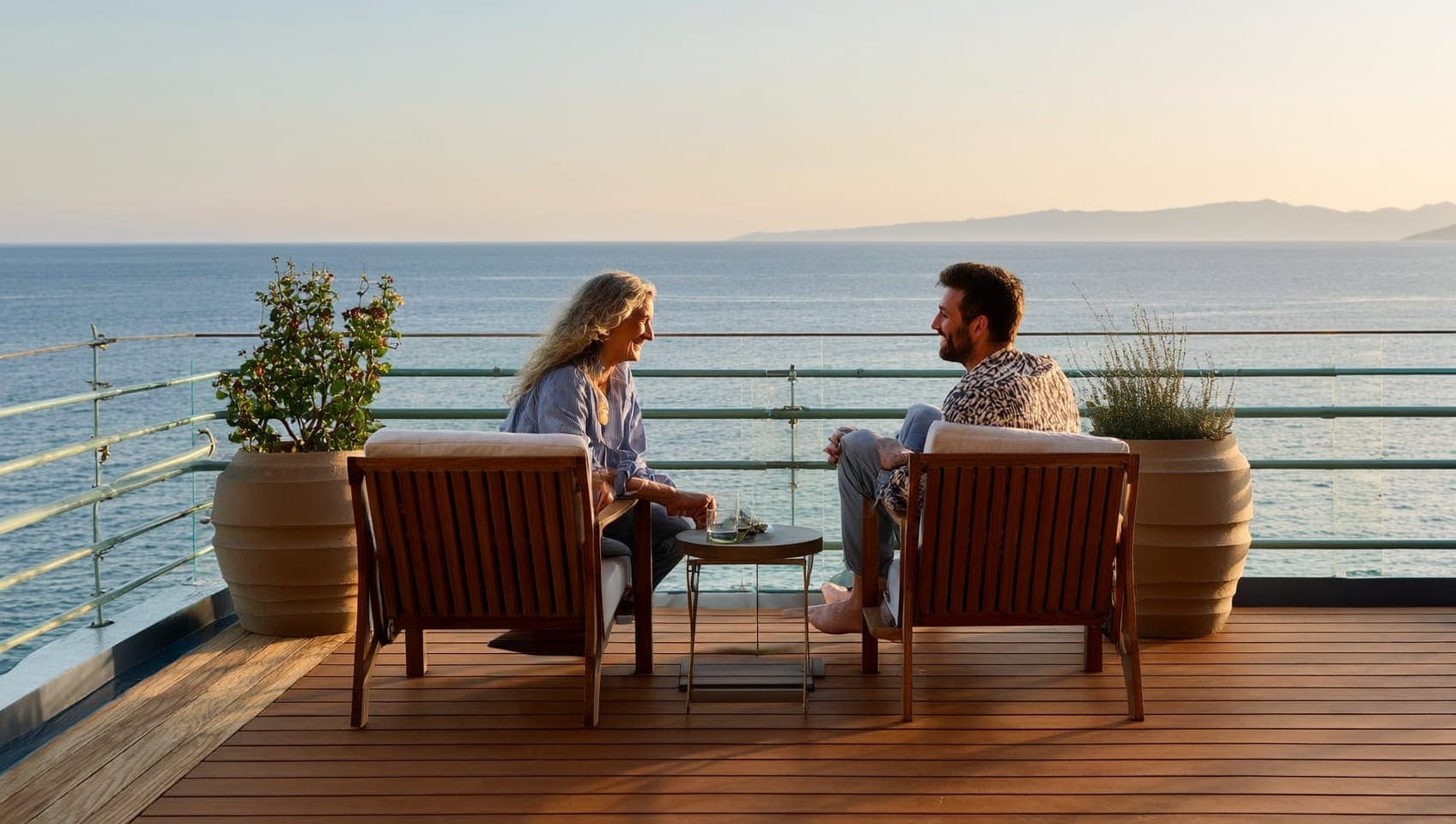 Diverse couple relaxing on a seaside terrace overseas at sunset